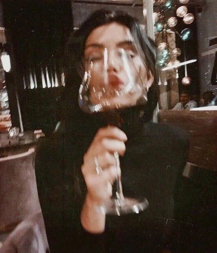 Une femme dégustant un verre de vin rouge