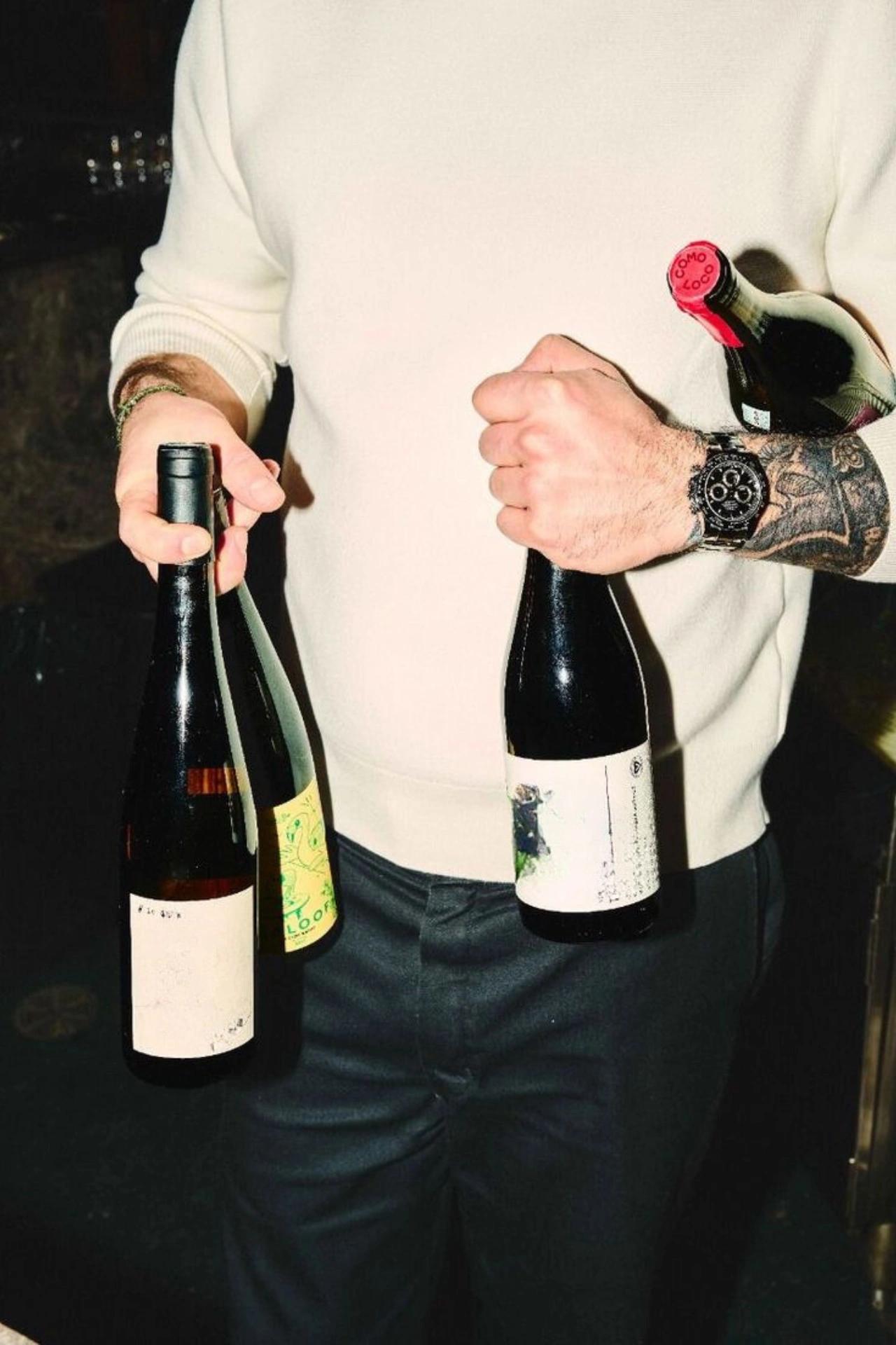 Un homme tenant des bouteilles de vin - Caviste en ligne