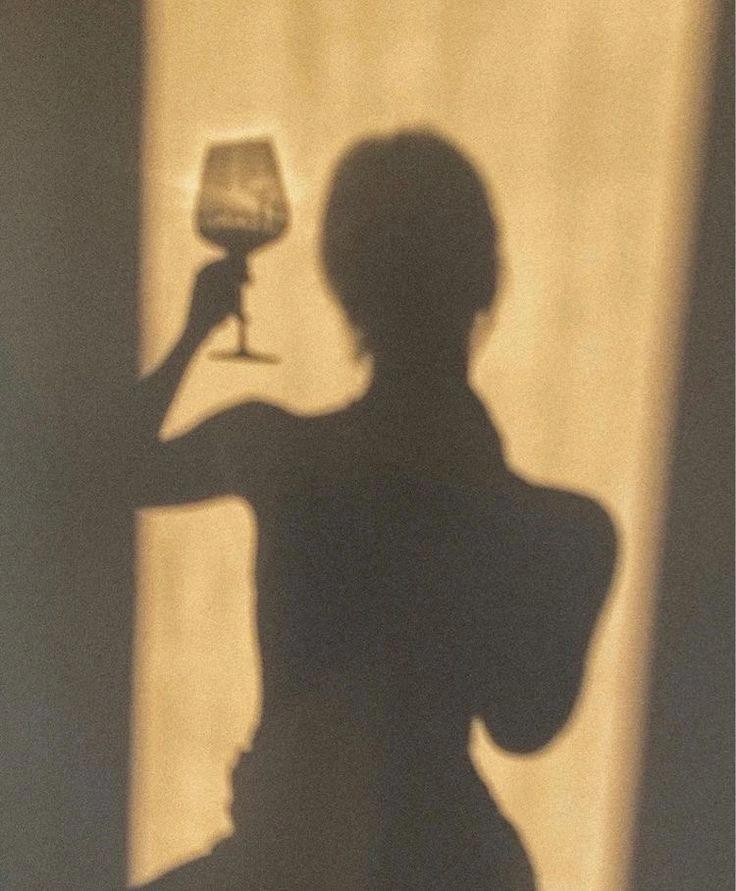 Silhouette d'une femme tenant un verre de vin blanc 