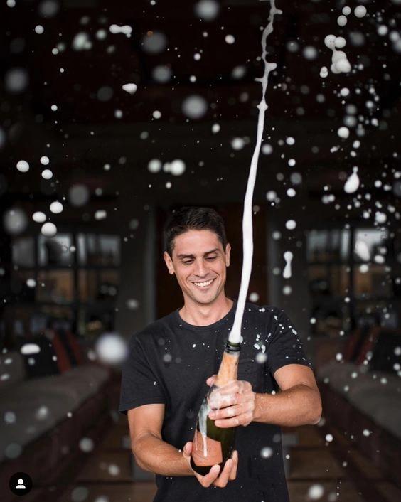 Une homme ouvrant une bouteille de champagne